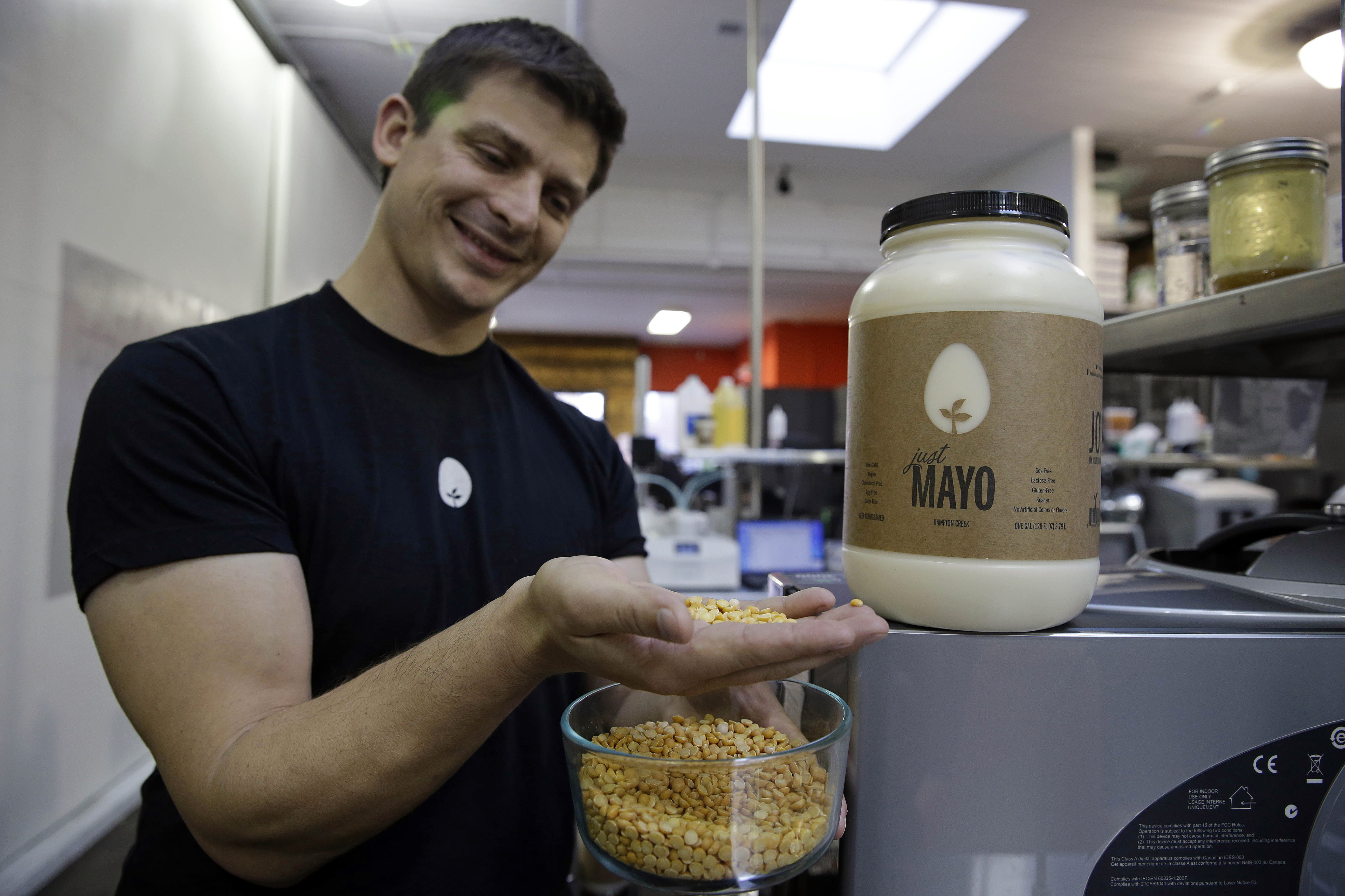 FILE - In this Dec. 3, 2013, file photo, Hampton Creek Foods CEO Josh Tetrick holds a species of yellow pea used to make Just Mayo, a plant-based mayonnaise, in San Francisco. The Agriculture Department says it is looking into documents that show that an egg industry organization under government oversight tried to harm sales of an imitation mayonnaise. According to email documents provided to The Associated Press, the American Egg Board tried to prevent Whole Foods retailers from selling Hampton Creek's eggless Just Mayo spread. The egg board is one of many industry promotional boards overseen by USDA but paid for by the industries themselves. By law, the boards cannot disparage other commodities. (AP Photo/Eric Risberg, File)