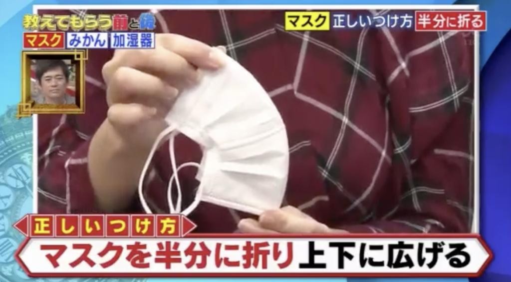 首先,先把乾淨的口罩對摺,再將對摺的口罩上下拉開。