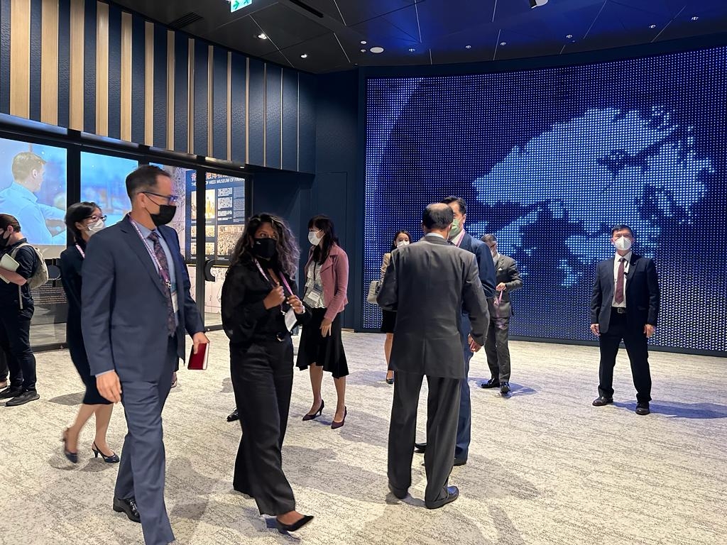 各國金融領袖由不戴口罩互相閒聊，仿如置身外國，然後一日之間全員戴回口罩，回到了真實的香港。