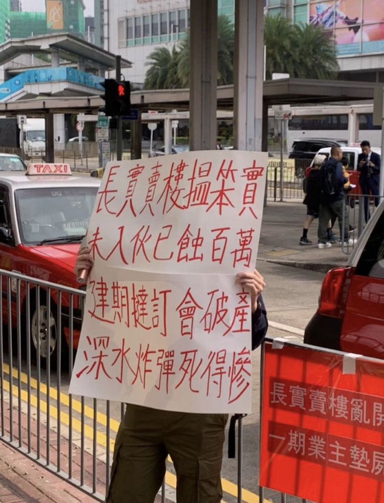 有飛揚一期業主不滿發展商減價去貨，曾在售樓處場外舉牌及派發單張抗議。