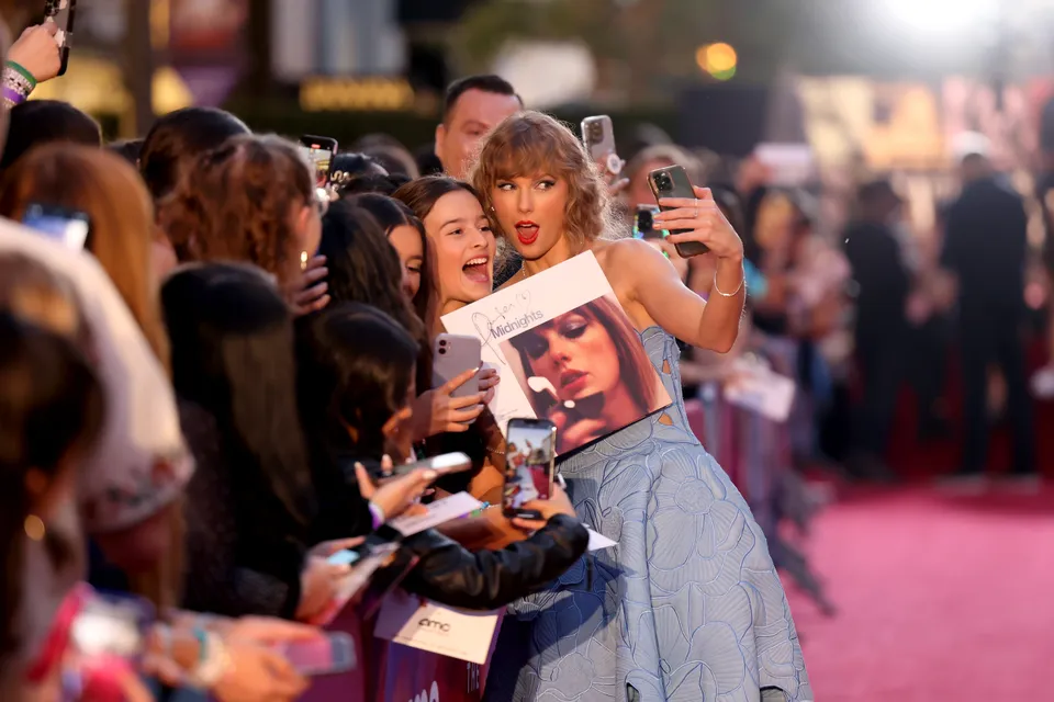 Taylor Swift在首映禮上與粉絲合影。